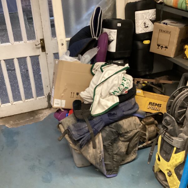 Large bundle of used horse covers and leg wraps for equine protection.