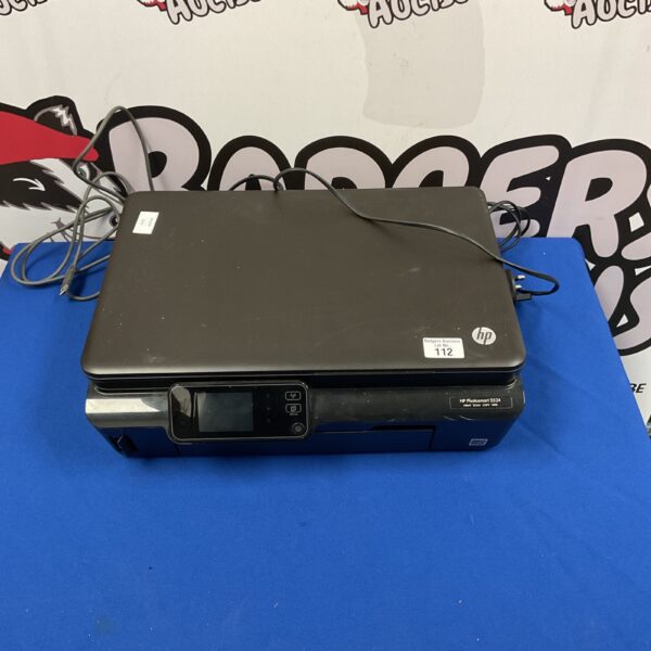 Front view of the HP Photosmart 5524 printer in used condition.