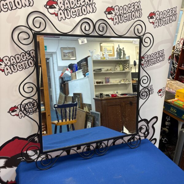 Black metal IKEA NORESUND mirror with swirling design.