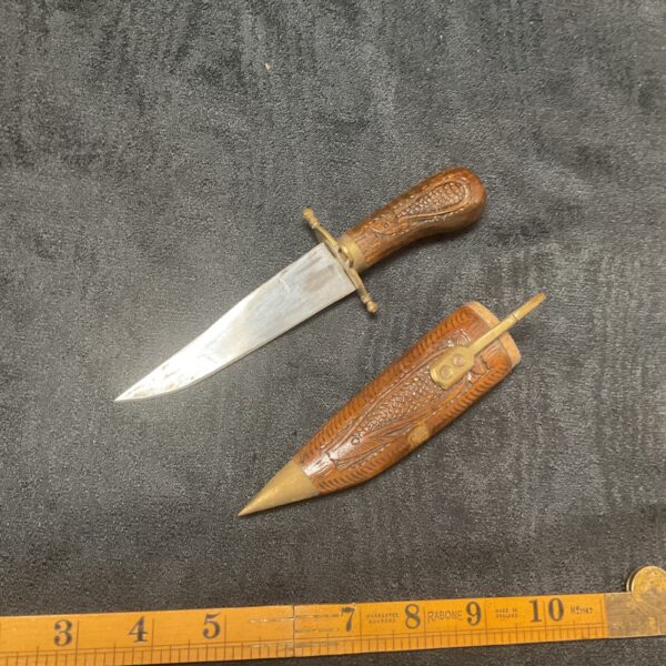 Vintage Indian carved knife with detailed wooden sheath.