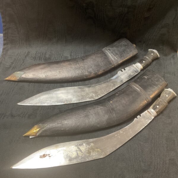 Pair of large Indian kukri knives with wooden handles.