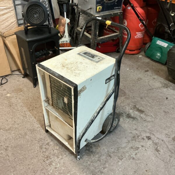 Vintage industrial dehumidifier with metal casing and wheels.