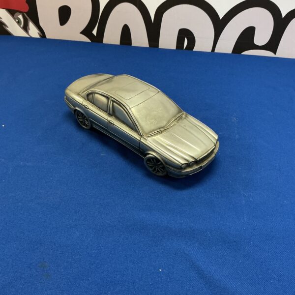 Silver metal sculpture of a Jaguar car, automotive art collectible.