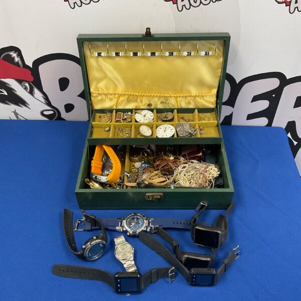 Open jewellery box filled with a large collection of vintage jewellery and watches.