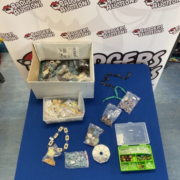 Mixed lot of colourful jewellery making supplies on a blue table.