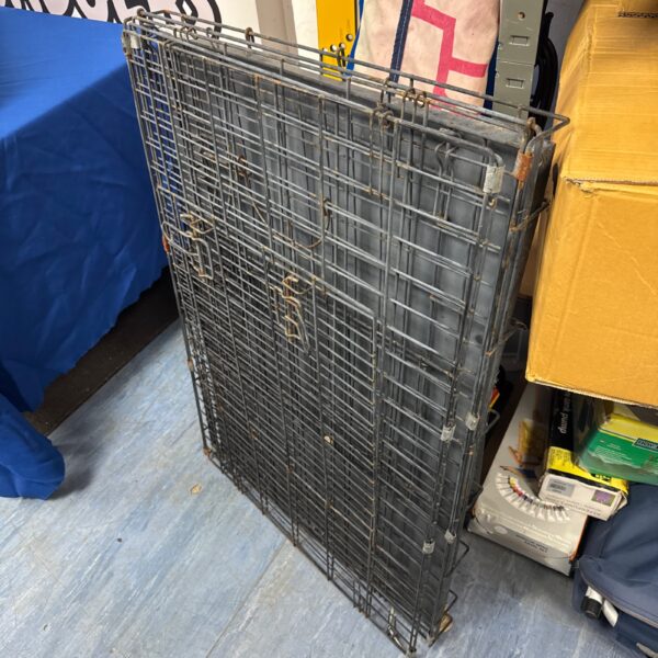 Large folding dog crate with wire mesh construction, side view.