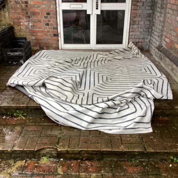 Large geometric rug with repeating pattern, ideal for home decor.