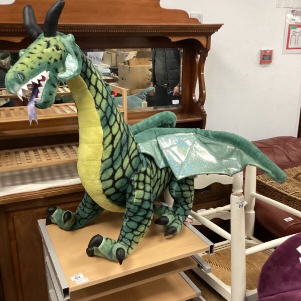 Large green plush dragon soft toy, detailed scales, fantasy creature.