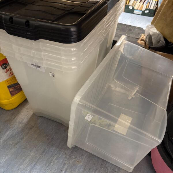 Stack of large plastic storage tubs for household organisation.