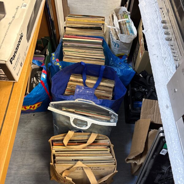 Large lot of mixed genre vinyl records in a blue bag.
