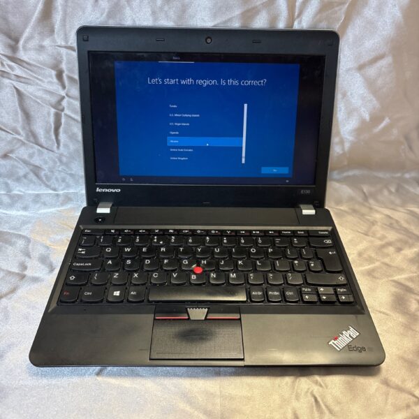 Black Lenovo Thinkpad laptop open on a white surface.