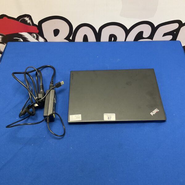 Front view of a used Lenovo Thinkpad laptop with charger.