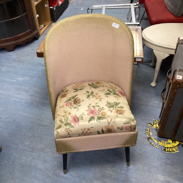 Vintage Lloyd Loom bedroom chair with floral upholstery.