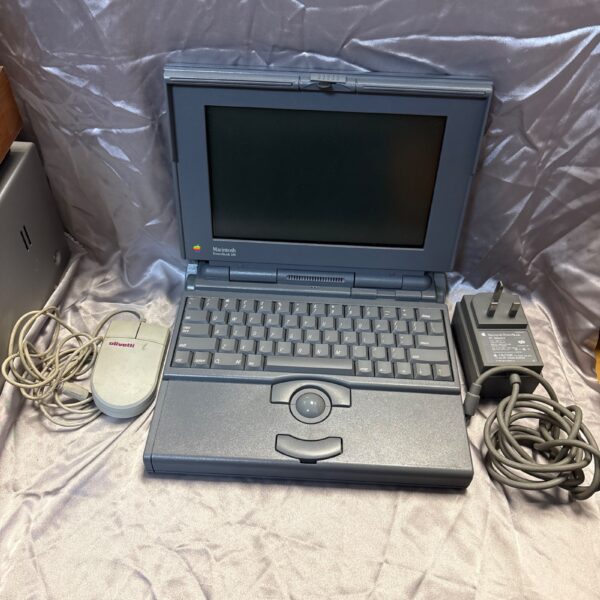 Vintage Macintosh PowerBook 180 laptop with power supply and mouse.