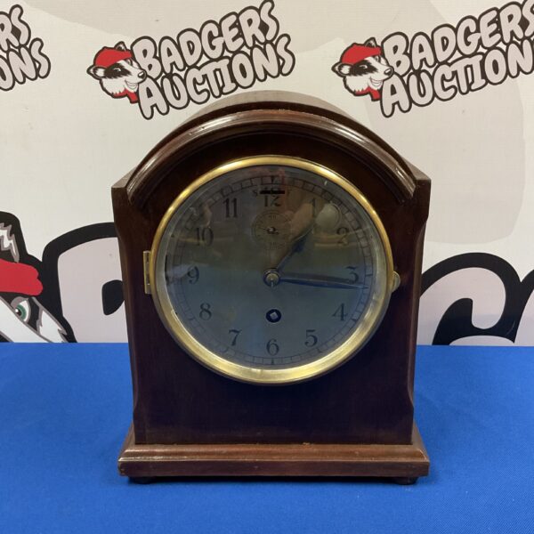 Antique mahogany mantle clock with Roman numerals.