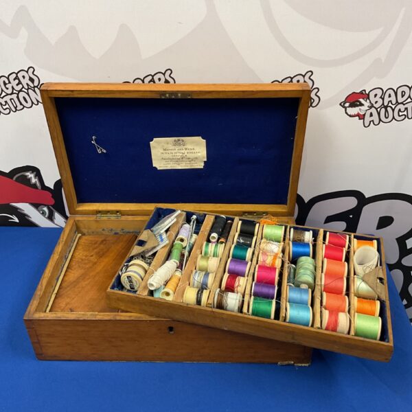 Vintage Mappin & Webb oak sewing box with colourful thread spools inside.