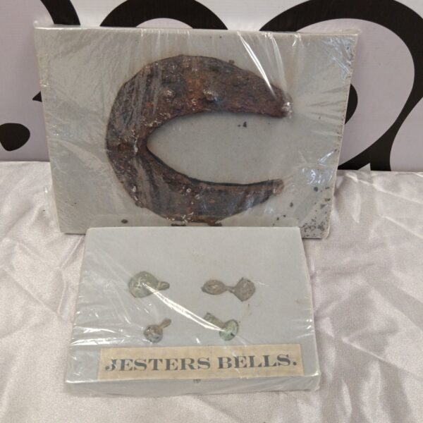 Antique medieval jester bells and horse shoe, weathered patina.