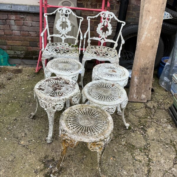 Vintage metal garden furniture set with ornate detailing.