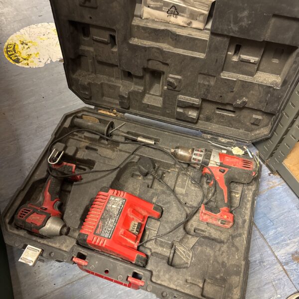 Open Milwaukee M18 tool set with drill, impact driver, and charger inside.