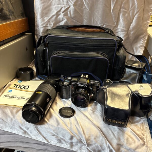 Vintage Minolta 7000 camera kit with lenses and travel bag.