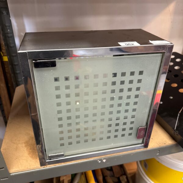 Small mirrored push close cabinet with geometric design.