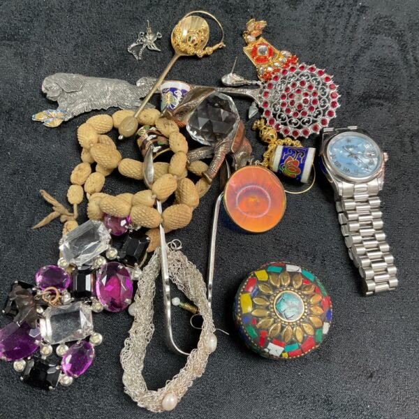 Colourful mixed jewellery lot with brooches, necklaces and a watch.