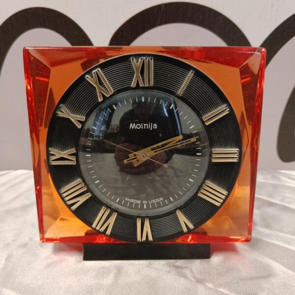 Vintage Molnija mantle clock with glass case and bold numerals.