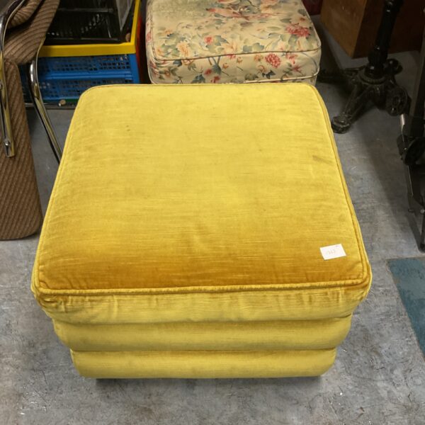 Vibrant mustard yellow pouffe footstool for retro home decor.