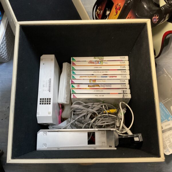 Nintendo Wii console with games and controllers, retro gaming system.
