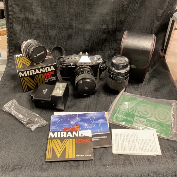 Vintage Olympus OM 30 SLR camera with lenses and flash gun.