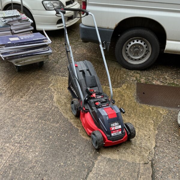 Cordless Ozito lawnmower in a garden setting.
