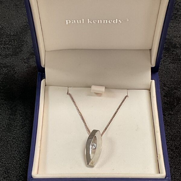 Paul Kennedy silver necklace with cubic zirconia pendant on display.