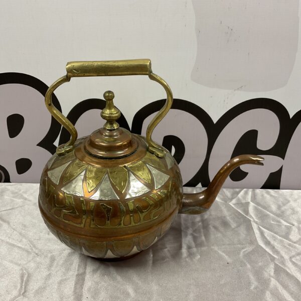 Antique Persian copper teapot with embossed detailing.