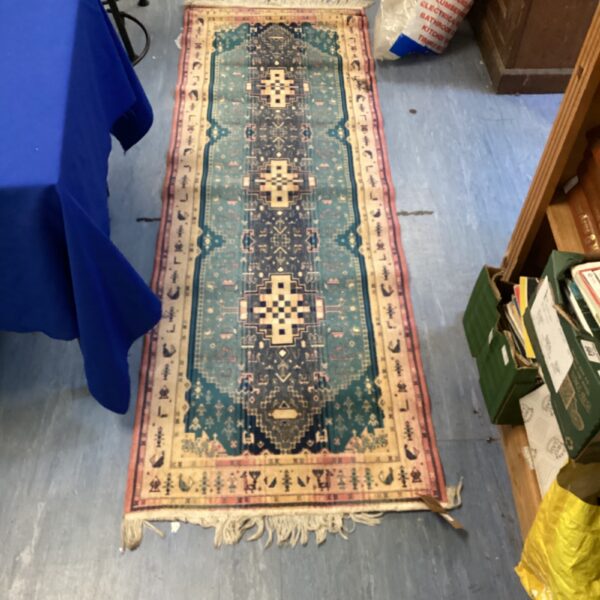 Intricate Persian silk runner rug with geometric and animal designs.