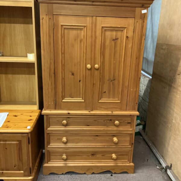 Vintage pine cupboard with three drawers, ideal for storage.