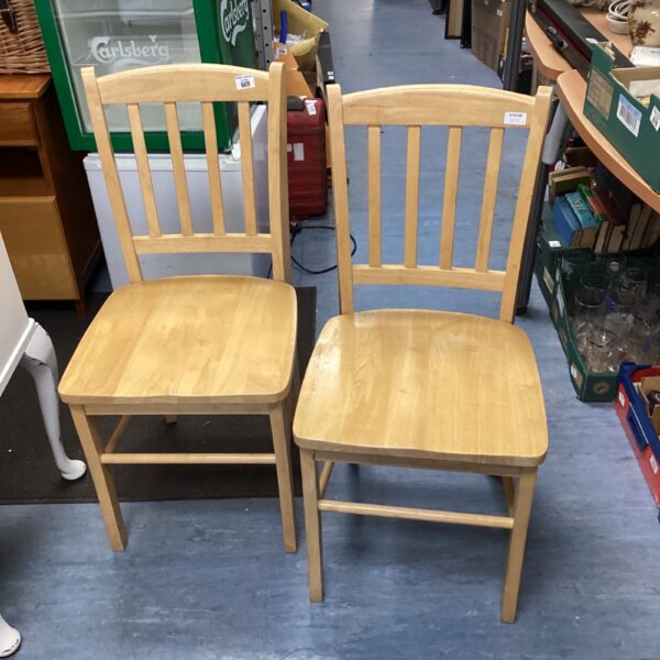 Pair of vintage pine stick back chairs in a rustic setting.