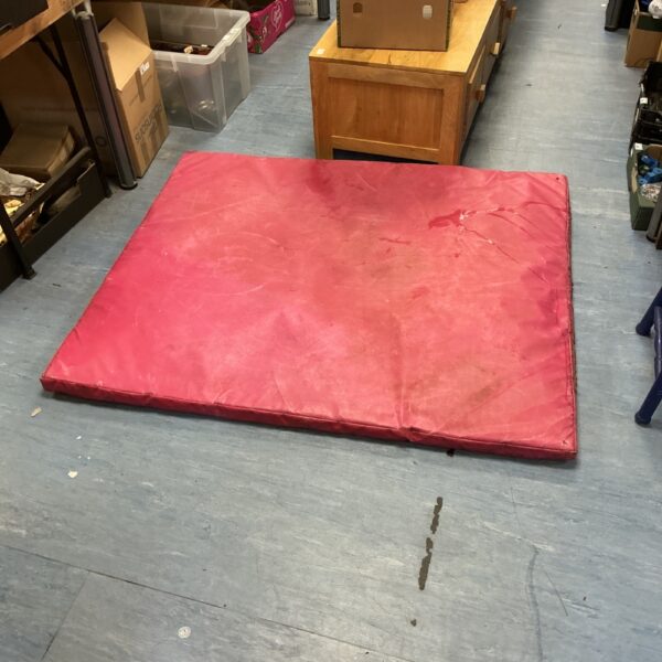 Pink crash mat for gymnastics and safety padding.