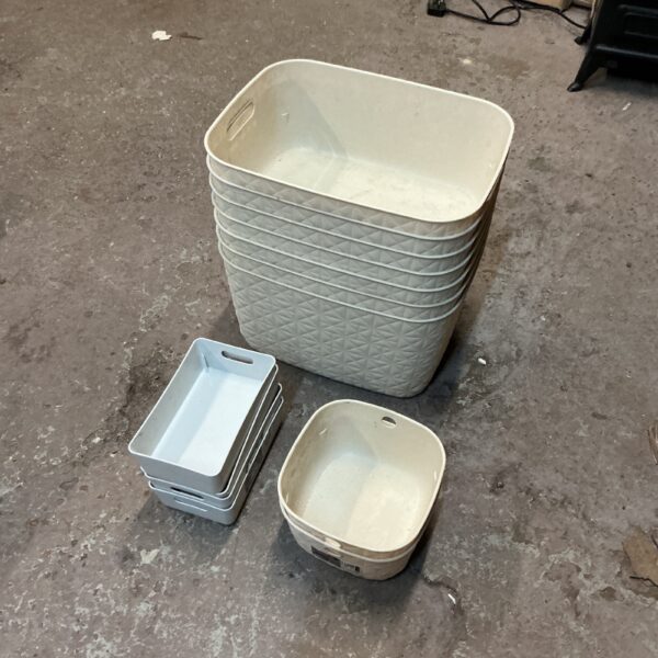 Stack of grey plastic storage boxes for household organization.
