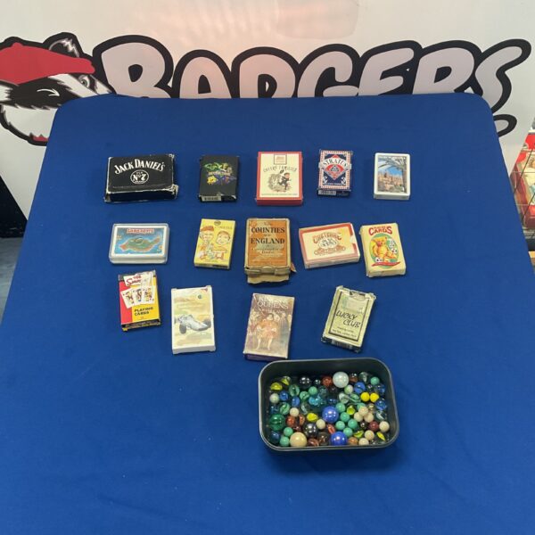 Variety of playing card packs and marbles in a collectible lot.