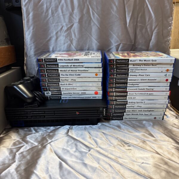 PlayStation 2 console and large collection of video games for sale.