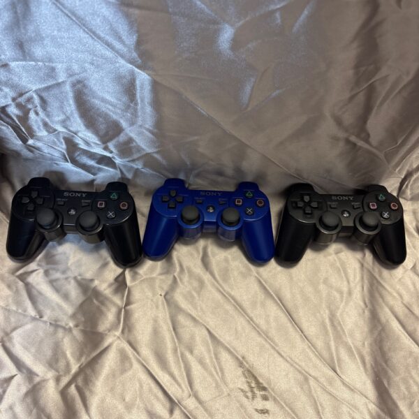 Lot of three used Sony PlayStation 3 controllers for gaming.