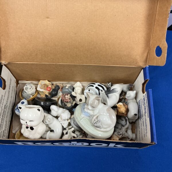Vintage porcelain cat figurines displayed in a collection.