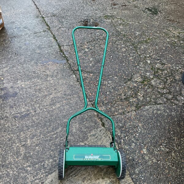 Vintage Qualcast Panther push mower in a garden setting.