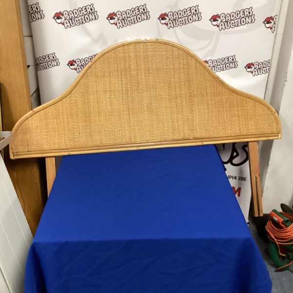 Vintage rattan headboard with curved top and woven texture.