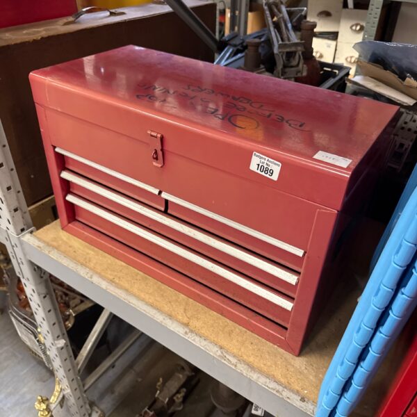 Red metal tool chest filled with tools, front view.