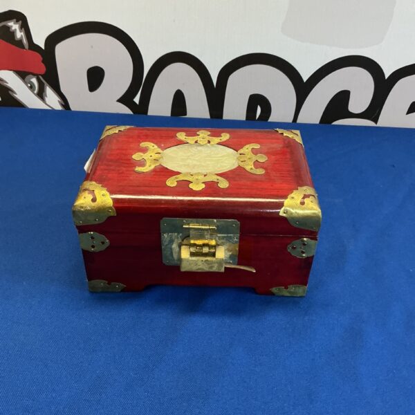 Red wooden jewellery box with gold detailing, vintage style.