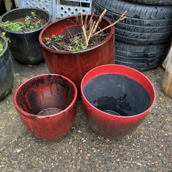 Trio of reddish-brown terracotta garden pots for outdoor plants.