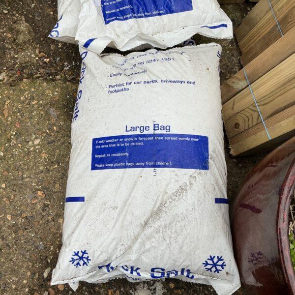 Partially used bags of rock salt for winter de-icing.