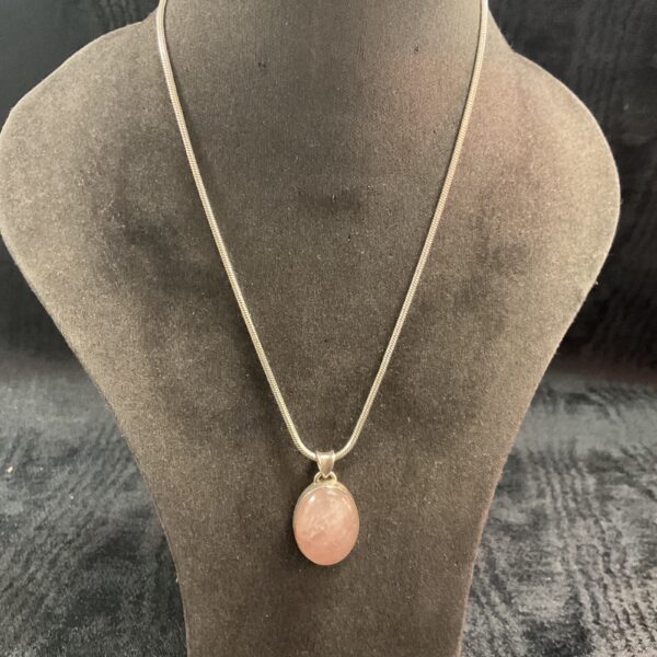 Glowing rose quartz pendant on a sterling silver necklace.