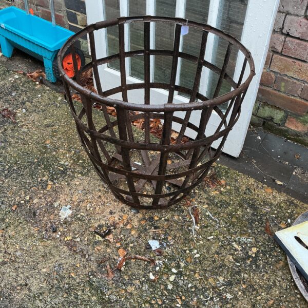 Rusted metal garden basket for plants and outdoor decor.